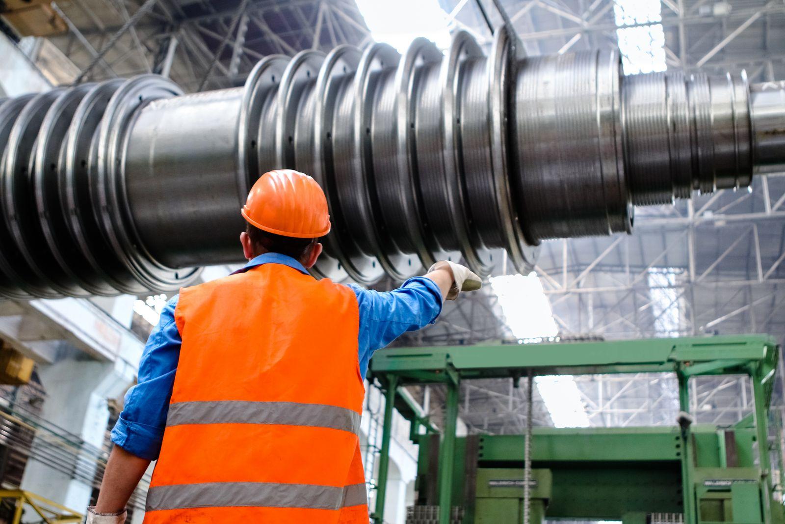 Engineer in hi-vis vest inspecting machinery