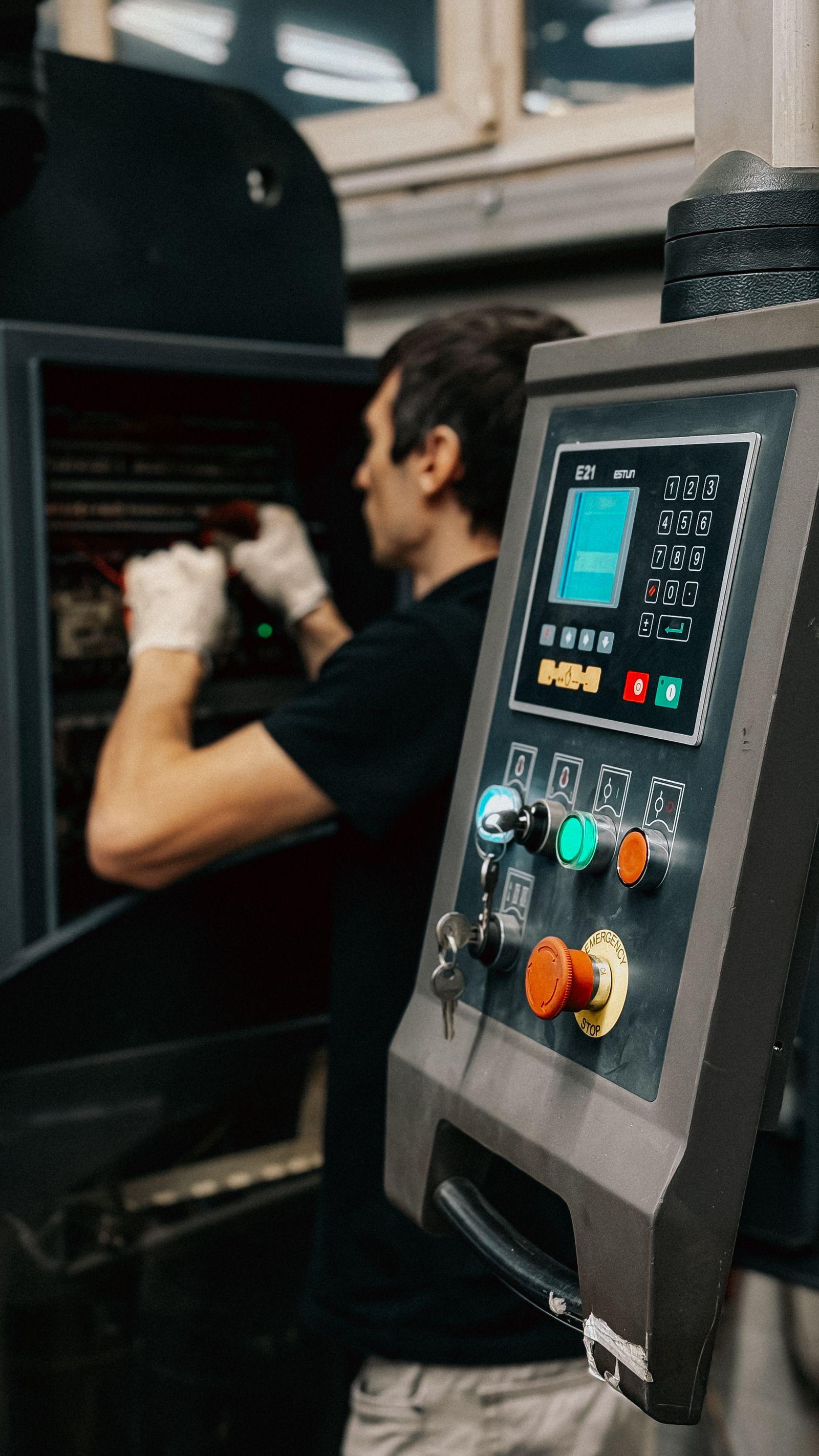 Worker operating a machinery control panel