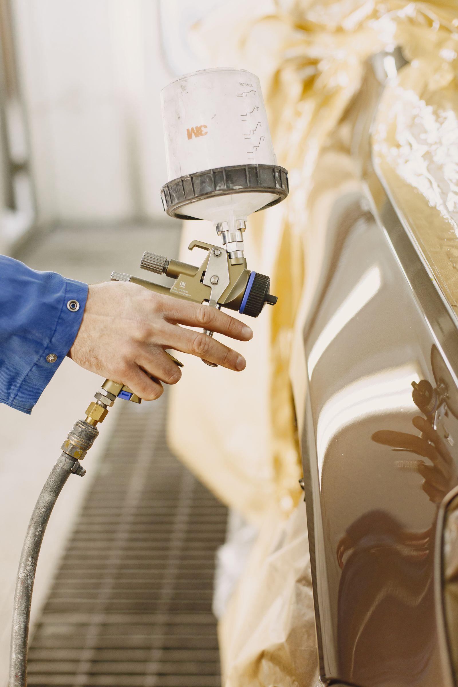 Worker using a paint spray gun
